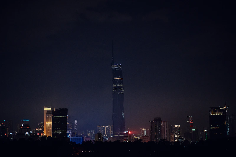 a very tall building towering over a city at night