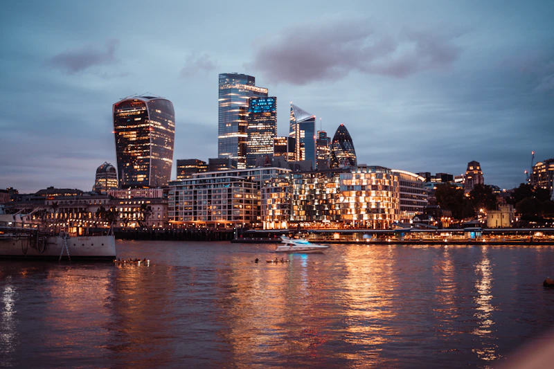 city skyline across body of water during night time