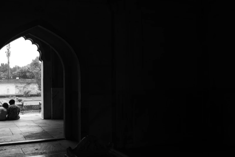 Two people sitting in an arched doorway