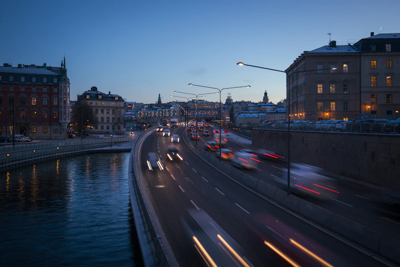 a street filled with lots of traffic next to a river